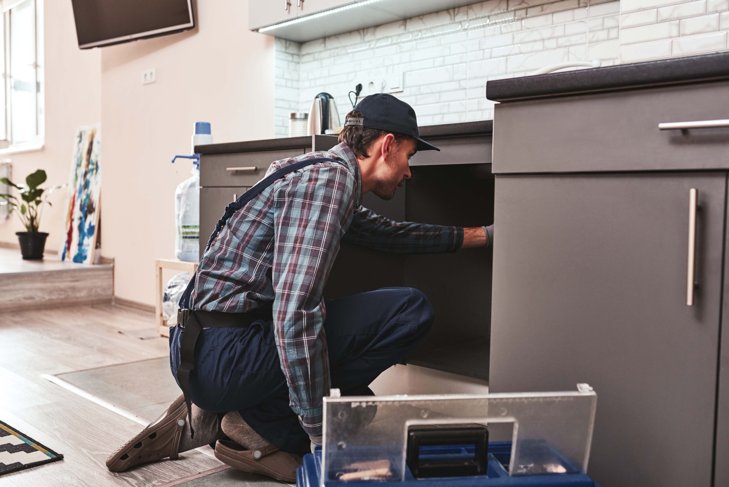 checking problems. young adult handyman repairing washbasin